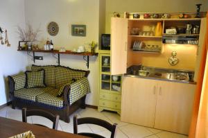 a living room with a couch and a kitchen at Casa al Centro Storico in Nicolosi