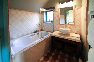 ein Badezimmer mit Badewanne und Waschbecken in der Unterkunft La Ferme de Bouchemont in Saint-Symphorien + 33 Fotos