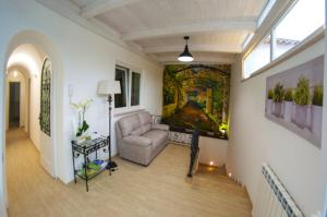 a living room with a couch and a painting on the wall at La Primavera in Anacapri