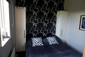 Schlafzimmer mit einem Bett mit einer schwarz-weißen Wand in der Unterkunft Södra Emmetorpsgatan 31 in Borgholm