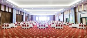 a large banquet hall with white tables and chairs at Muong Thanh Grand Hoang Mai - Nghe An in Hoang Mai