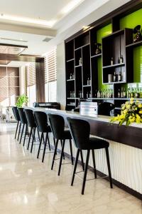 a bar with black chairs and a long counter at Muong Thanh Grand Hoang Mai - Nghe An in Hoang Mai