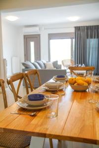 una mesa de madera con platos y cuencos de fruta. en Legno Bianco, en Stalida