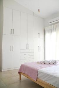 a white bedroom with a bed with white cabinets at Legno Bianco in Stalida +20 photos