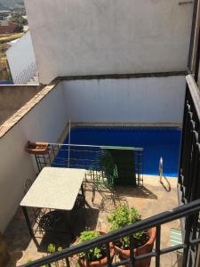 a balcony with a table and a blue pool at Los Gañanes in Puebla de Don Rodrigo