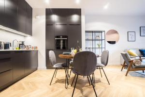 a kitchen and dining room with a table and chairs at VipWarsawApartments Onyx Mennica Residence in Warsaw