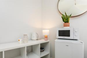 a living room with a microwave and a tv on a counter at Beautiful pied-a-terre to explore London in London