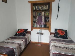 a room with two beds and a book shelf at Villa Valentina Issyk-Kul in Grigor'yevka