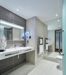 a bathroom with a sink and a toilet and a mirror at The Hotel at Mill Farm in Kirkham