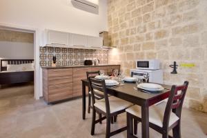 a dining room with a table and chairs in a kitchen at Vallettastay Classic Apartments in Valletta