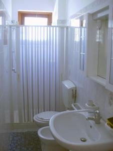 a bathroom with two toilets and a sink and a shower at Casa Orchidea in Lipari