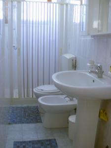 a white bathroom with a sink and a toilet at Casa Orchidea in Lipari