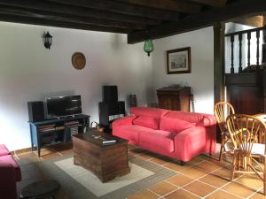sala de estar con sofá rojo y TV en Querencia, en Carmona