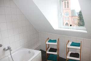 baño con lavabo, bañera y ventana en Fewo Lorri, en Dorsten