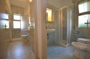 a bathroom with a sink and a toilet and a shower at Ville Dogi Sud in Bibione