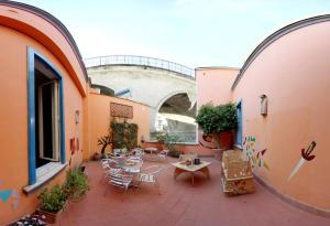 un patio al aire libre con mesas y sillas en un edificio en Casa del Monacone en Nápoles