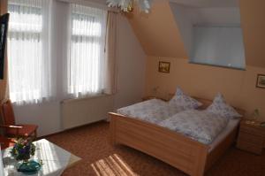 Un dormitorio con una cama con almohadas. en Pension & Ferienwohnung "Villa Agnesruh", en Bad Elster