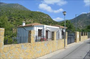 a building with a stone wall with a gate at Casa MamaTere in Benamahoma