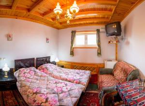 a bedroom with a bed and a couch and a tv at Furkat Guest House in Samarkand
