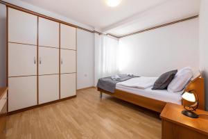 a bedroom with a bed with white cabinets and a desk at Apartments Santos in Vrsar