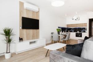 a living room with a couch and a table at Apartments Warsaw Przyokopowa by Renters in Warsaw