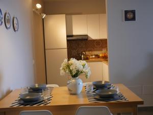 eine Küche mit einem Holztisch mit einer Blumenvase in der Unterkunft Poggio Miramare Luxury Home in Castellammare di Stabia