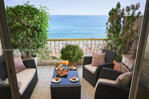 a balcony with a table with food and the ocean at Sunlight Properties - "Maryland " - Sea Front in Nice