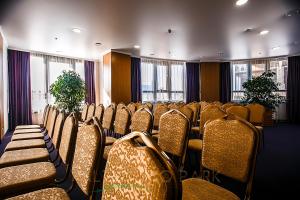 una sala de conferencias con filas de sillas y ventanas en Altyn Eco Park, en Astana