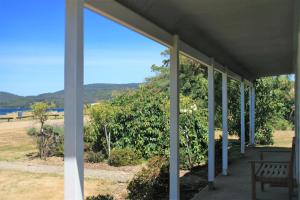 a porch with a bench and a view of the water at Castaway Cottage in Dover