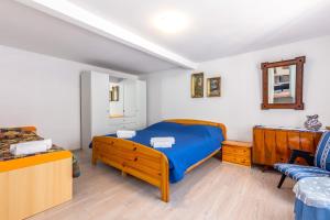 een slaapkamer met een blauw bed en een bank bij Apartment Lucija in Bakar