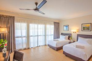 a hotel room with two beds and a ceiling fan at Camar Resort Langkawi in Pantai Cenang
