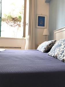 a bedroom with a bed with blue sheets and a window at Il Miraggio in Fregene