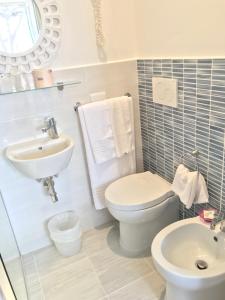 a bathroom with a toilet and a sink at Il Miraggio in Fregene