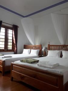 two twin beds in a room withthritisthritislictslicts at Hiep Hoa Resort in Mui Ne