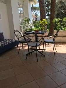 a patio with four chairs and a table and a couch at Il Miraggio in Fregene