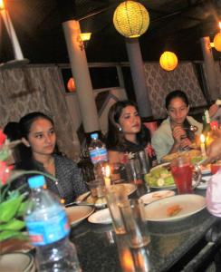 grupa ludzi siedzących przy stole jedzących w obiekcie Hotel Vision w mieście Gorkhā