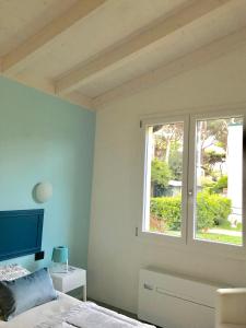 a bedroom with a bed and a window at Il Miraggio in Fregene