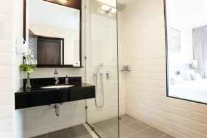a bathroom with a shower and a sink and a mirror at Deevana Plaza Krabi Aonang - SHA Extra Plus in Ao Nang Beach