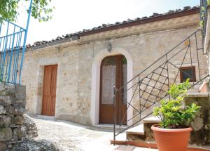 Casa de piedra con escalera y puerta en Residenza Bove Incoronato, en Bovino