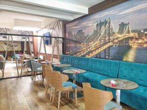 a restaurant with a blue couch and tables and chairs at Hotel Turist 98 in Jajce