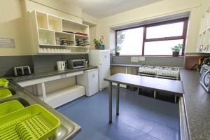 a kitchen with a table and a refrigerator at YHA Snowdon Llanberis in Llanberis