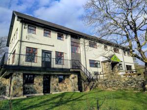 an old stone house with a balcony on a hill at YHA Snowdon Llanberis in Llanberis