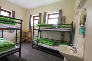 a room with three bunk beds and a sink at YHA Snowdon Llanberis in Llanberis