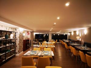 uma sala de jantar com mesas e cadeiras amarelas em Hotel Boutique Aquaria Caneliñas no Portonovo