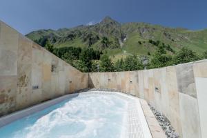a swimming pool with a mountain in the background at Relais & Châteaux Chasa Montana in Samnaun
