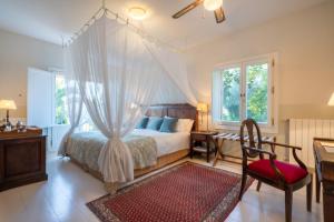 a bedroom with a bed and a desk and a chair at Hotel La Fuente de la Higuera in Ronda +59 photos