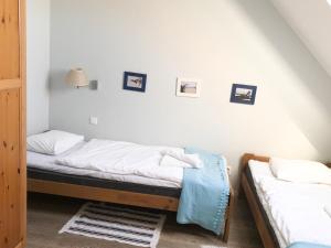 twee bedden in een kamer met foto's aan de muur bij Widok in Jastrzębia Góra