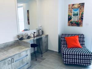 a room with a chair and a desk with a red pillow at White 11 in Larnaca
