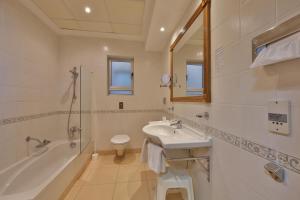 a bathroom with a sink and a shower and a toilet at Paradise Bay Resort in Mellieħa