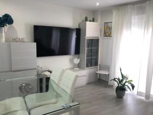 een woonkamer met een flatscreen-tv aan de muur bij APARTAMENTO 128 ESPINEL in Ronda
